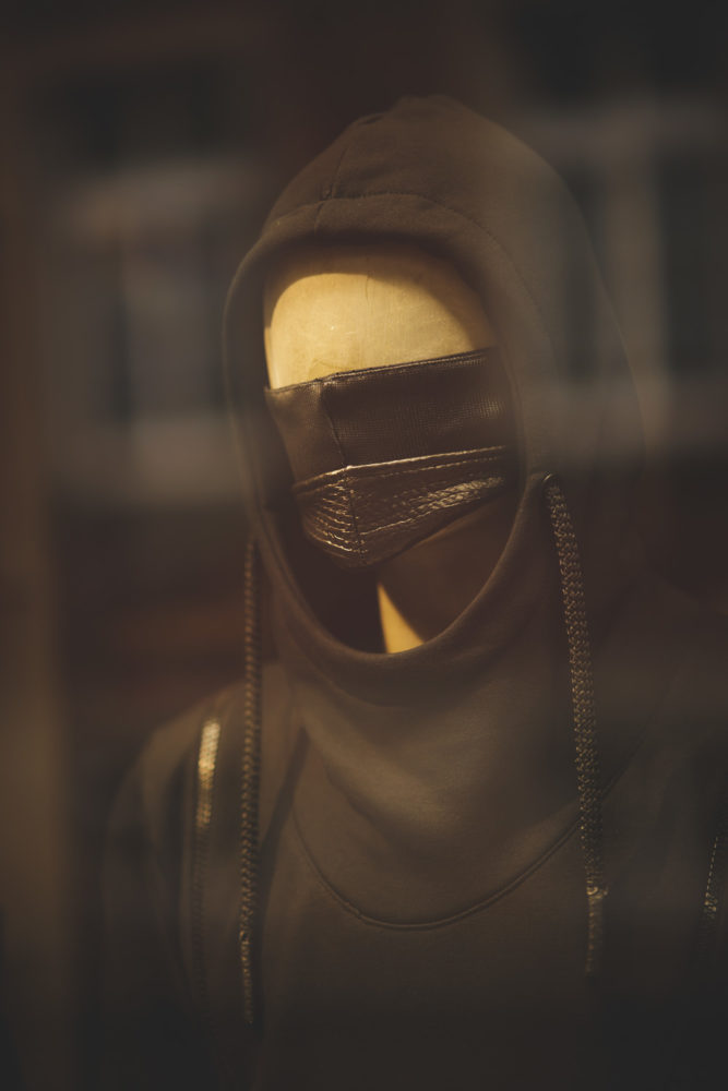 Schaufensterpuppe mit schwarzer Maske in schwarzem Hoodie