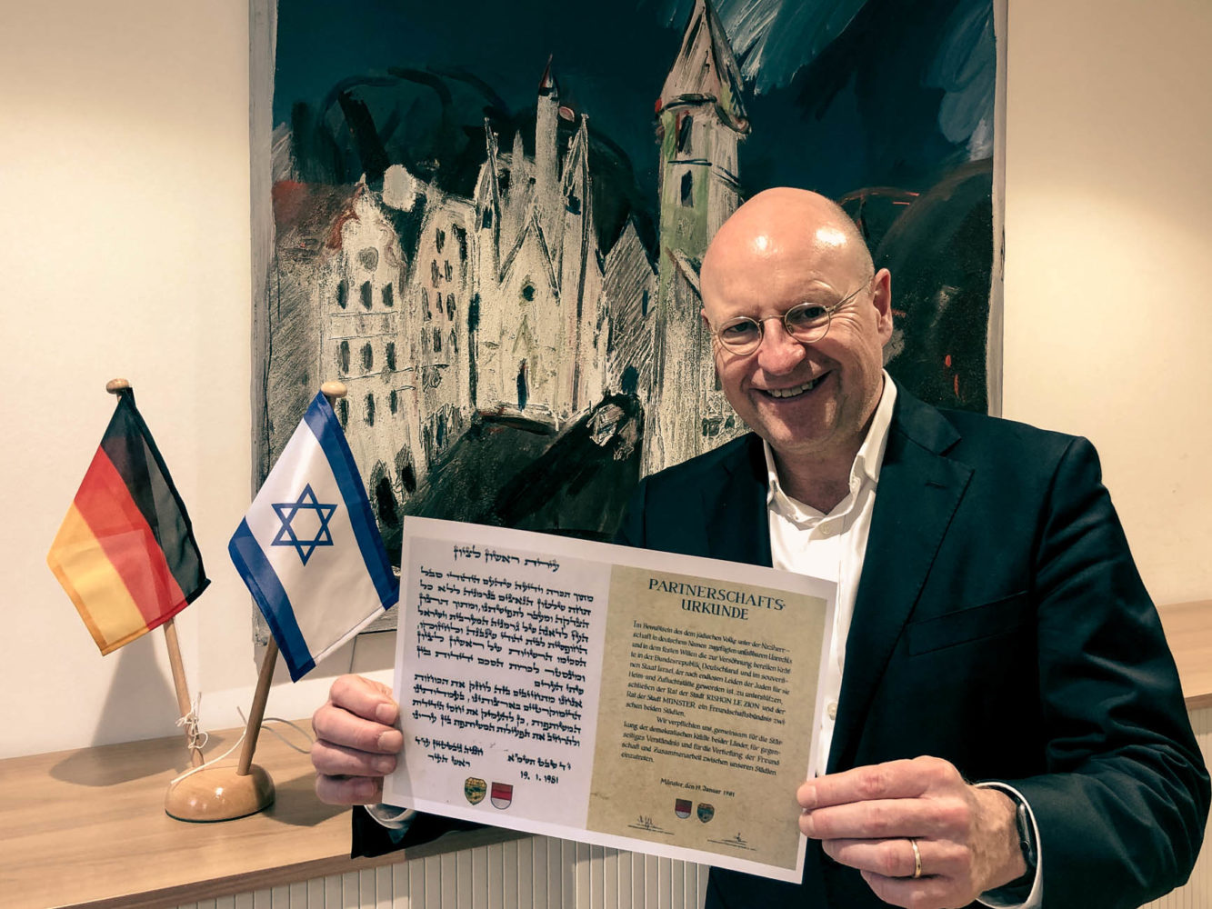 Oberbürgermeister Markus Lewe präsentiert die Urkunde, mit der die Partnerschaft zwischen Rishon LeZion und Münster vor genau 40 Jahren besiegelt wurde. Foto: Stadt Münster.