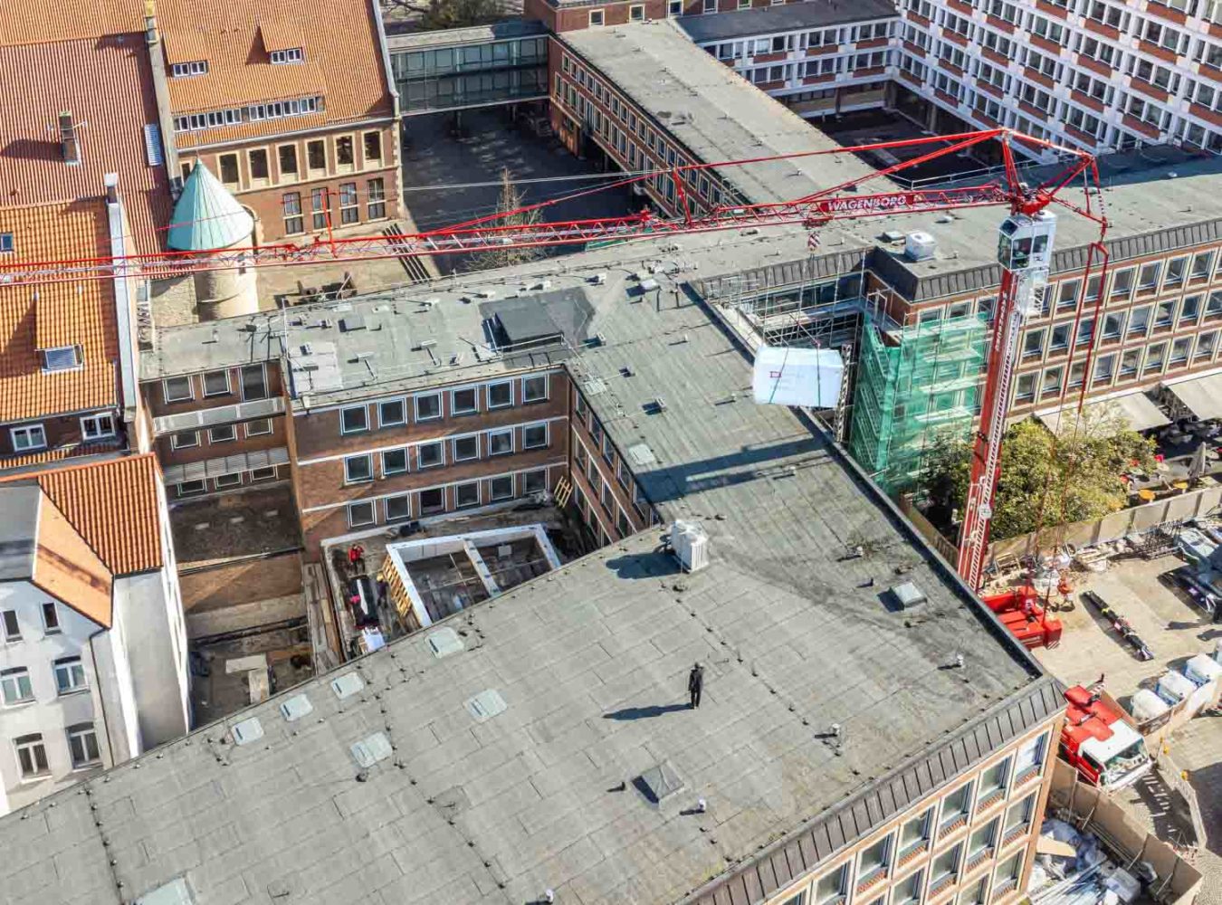 Teile des neuen Daches für den Stadthaussaal hebt der Kran über das viergeschossige Gebäude des Stadthauses 1. Foto: Stadt Münster / Münsterview.
